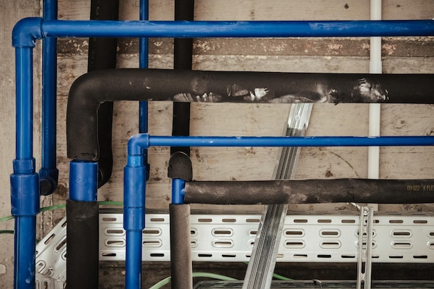 Photo vue rapprochée des tuyaux noirs et bleus dans un bâtiment