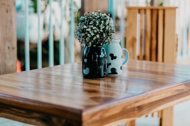 Vue rapprochée de l'usine avec un récipient sur une table en bois