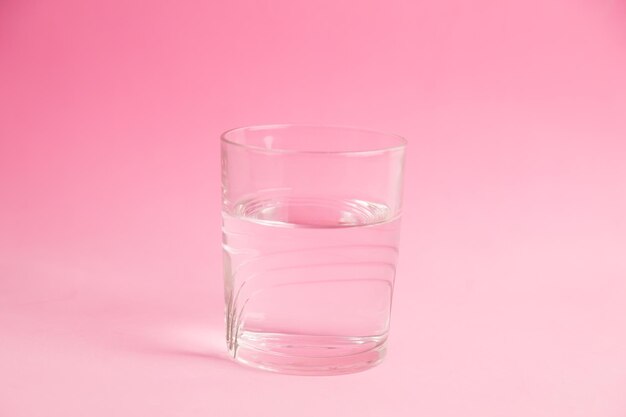 Vue rapprochée d'un verre d'eau sur un fond rose