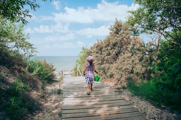 Vue rare d'une petite fille allant à la plage en mer Baltique