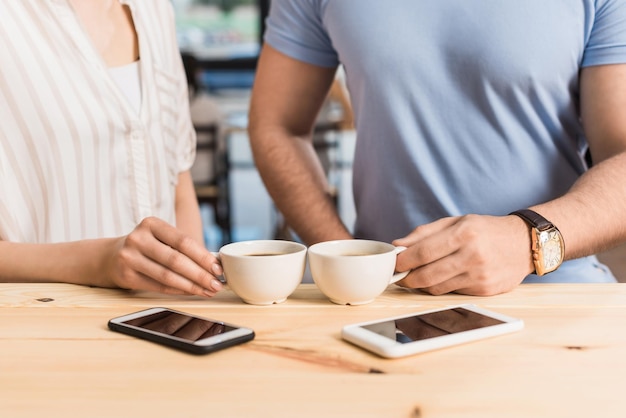 Vue recadrée du jeune couple buvant du café au comptoir du bar