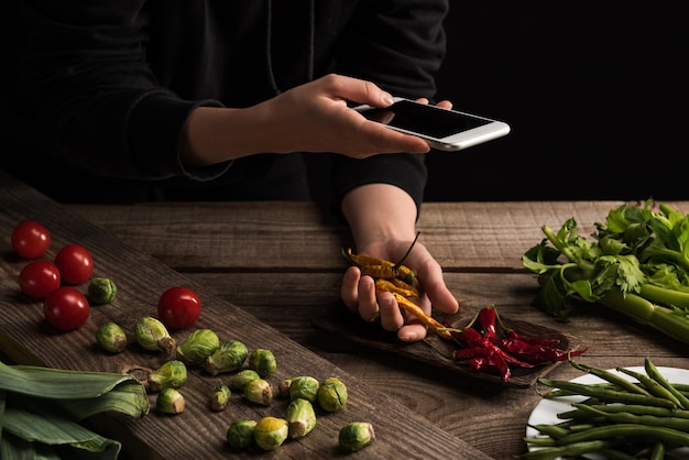 Vue recadrée du photographe faisant la composition alimentaire pour la photographie commerciale sur smartphone sur