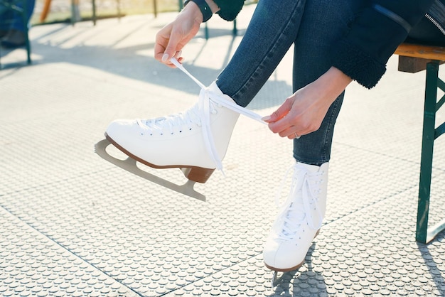 Vue recadrée d'une femme attachant des lacets de chaussures sur une bannière de patins à glace