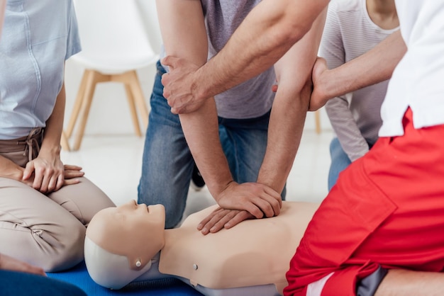 Vue recadrée d'un groupe de personnes pendant la formation aux premiers secours avec mannequin