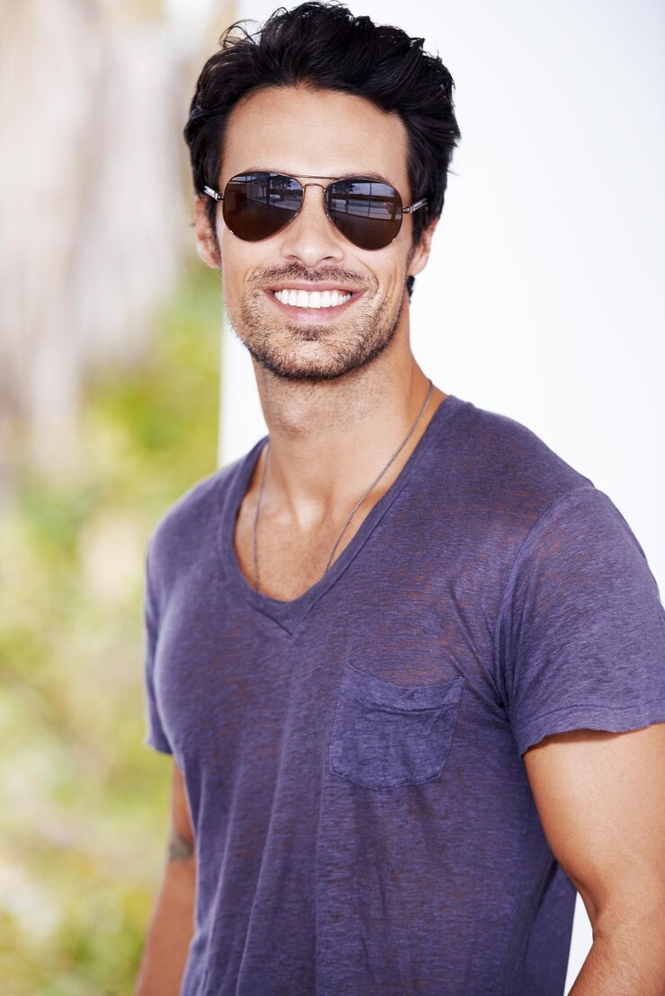 Photo vue recadrée d'un jeune homme branché souriant tout en portant des lunettes de soleil