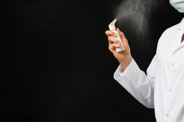 Vue recadrée de la main féminine à l'aide d'un spray