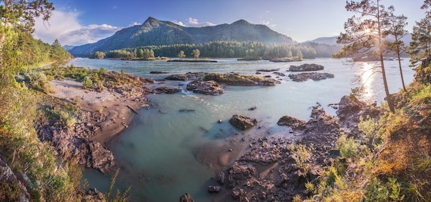 Vue d'une rivière de montagne le soir allumer le soleil couchant un rivage rocheux