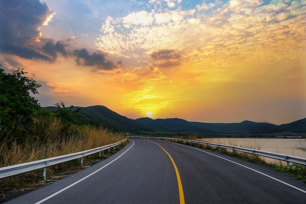 Vue sur la route goudronnée le matin avec montagnes et rivières et partiellement nuageux