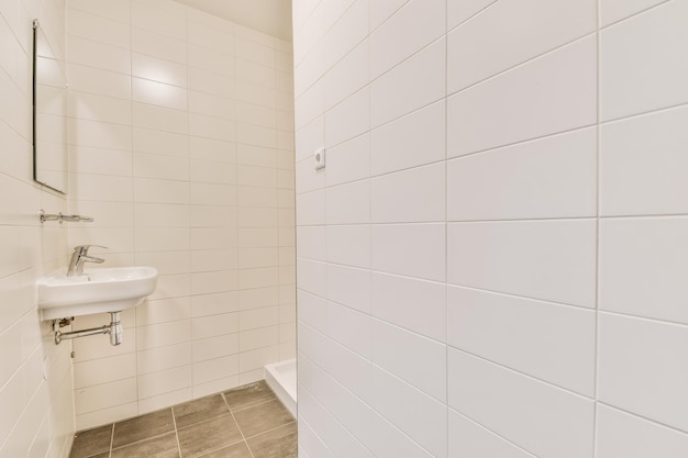 Vue de la salle de bain avec lavabo en céramique et entrée de la douche dans une maison moderne