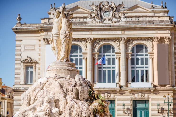 Photo vue sur la statue des trois grâces avec l'opéra en arrière-plan dans la ville de montpellier en france