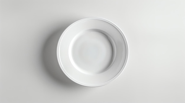 Vue supérieure d'une assiette blanche vide sur un fond blanc L'assiette est ronde et a un large bord Elle est assise sur une table blanche