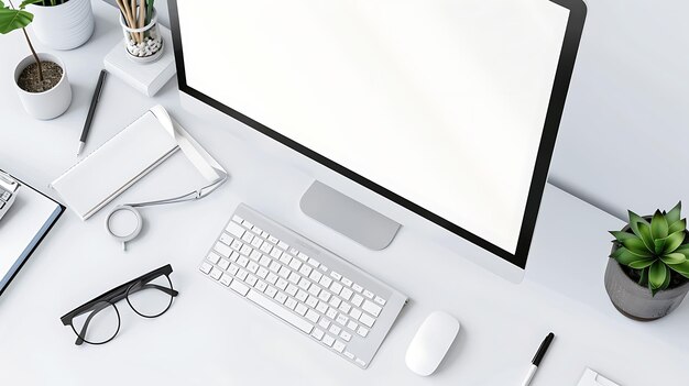 Vue supérieure d'un bureau avec un clavier iMac blanc, une souris, un portable, des lunettes, un stylo et des plantes. Le bureau est de couleur blanche.