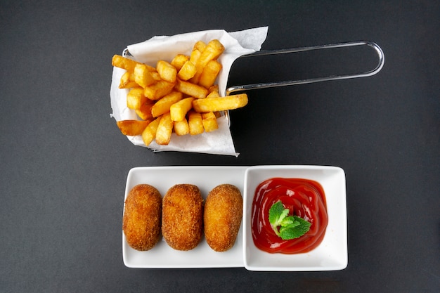 Vue supérieure de croquettes avec frites et tomate frite