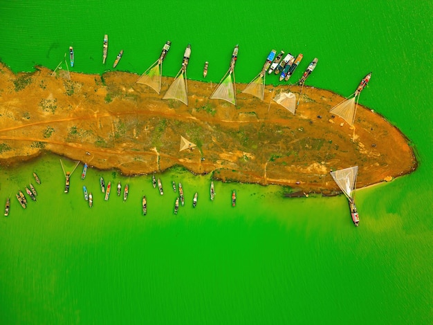 Vue supérieure du village de pêcheurs de Ben Nom image verte fraîche de la saison des algues vertes sur le lac Tri An avec de nombreux bateaux de pêche traditionnels ancrés à Dong Nai au Vietnam