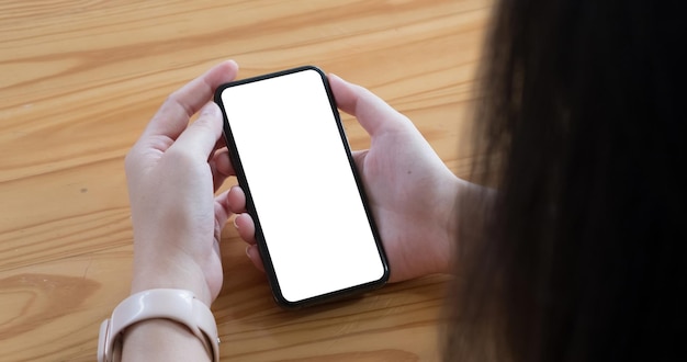 Vue supérieure femme assise et tenant un téléphone portable à écran vide