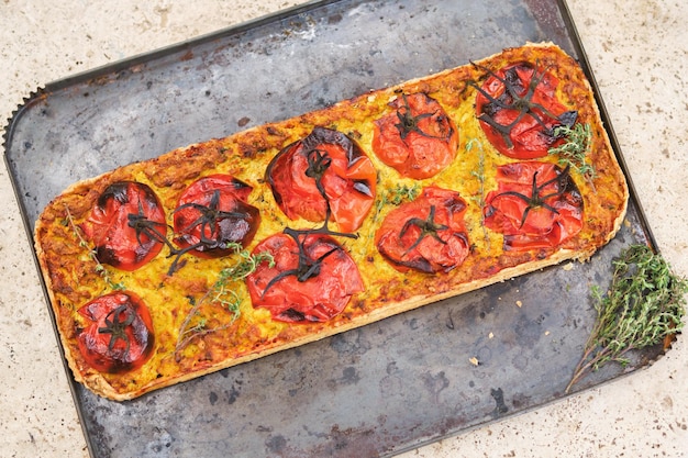 Vue supérieure pizza délicieuse fraîchement cuite avec des tomates mûres et du fromage placée sur la casserole sur la table de la cuisine