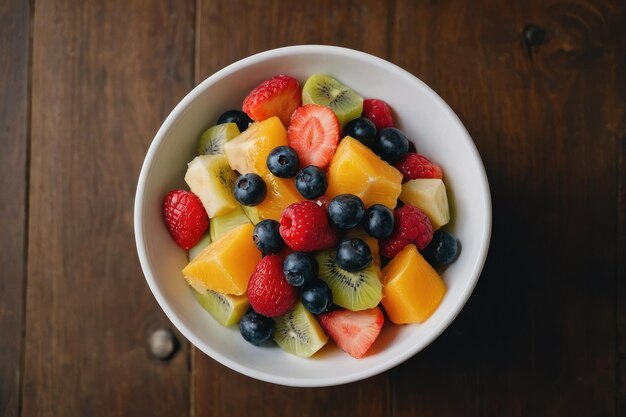 vue supérieure salade de fruits sur un bol blanc sur une table brune