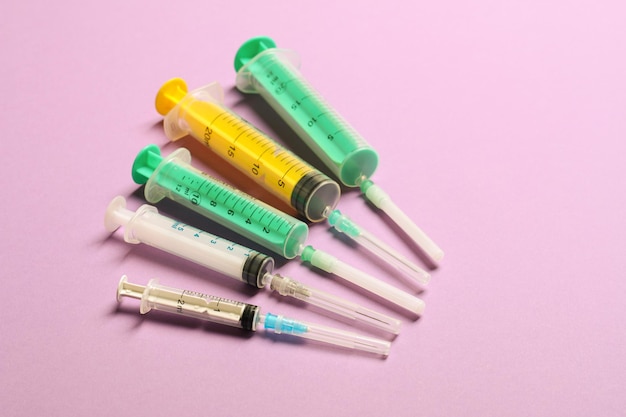 Vue supérieure de seringues médicales avec aiguilles sur fond violet avec espace de copie Concept de traitement par injection