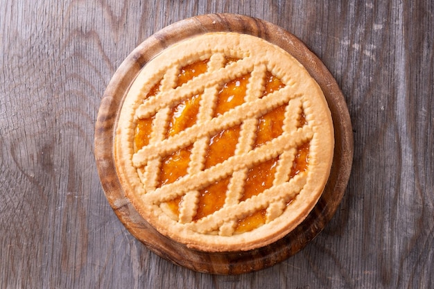 Vue supérieure d'une tarte avec de la confiture de pêche sur une table rustique en bois