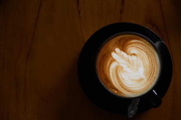 Vue supérieure d'une tasse de café avec une belle peinture Latte sur fond de bois concept de café