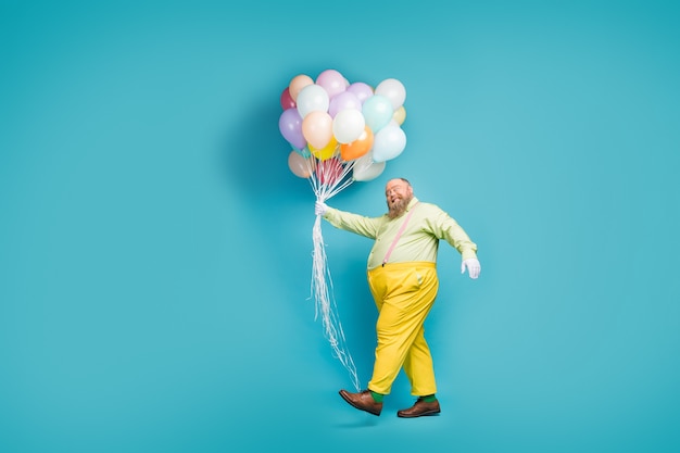 Vue de la taille du corps sur toute la longueur de l'homme marchant transportant la livraison de ballon air ball