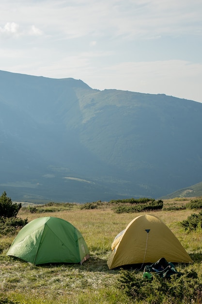 Vue de la tente touristique dans les montagnes au lever ou au coucher du soleil. Fond de camping