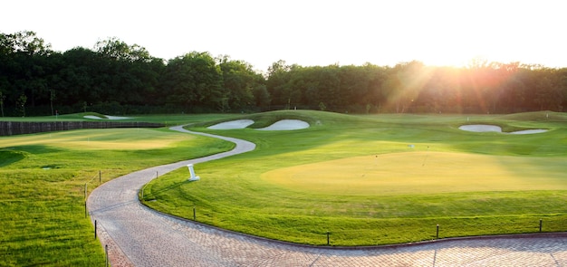 Photo vue sur le terrain de golf vert et la lumière du soleil