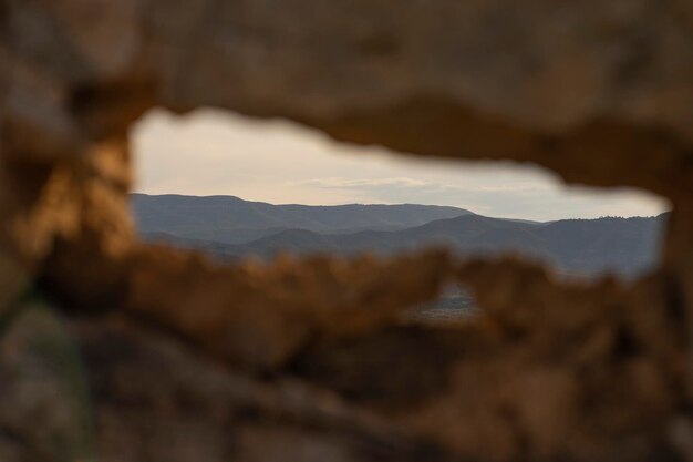 Une vue à travers un trou dans le mur d'une montagne