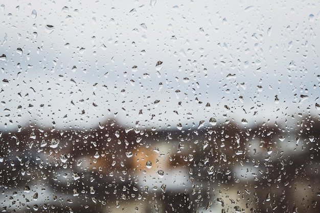 Vue à travers la vitre humide des gouttes d'eau de pluie terne temps d'automne copie espace