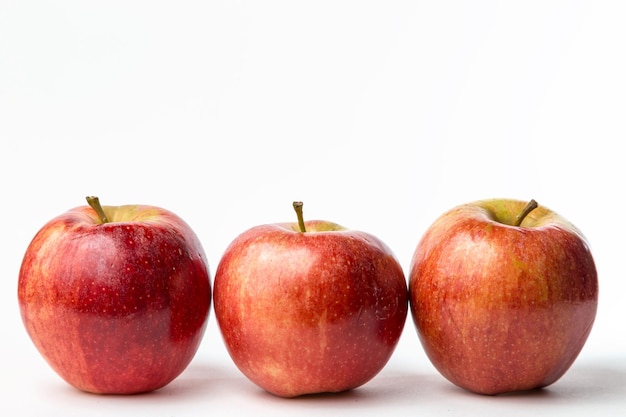 Vue de trois pommes rouges sur fond blanc