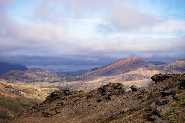 Vue sur la vallée de la montagne avec ses collines verdoyantes, son ruisseau et son lac. Sentier de randonnée Laugavegur, Islande.