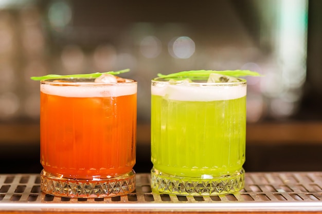 Vue sur verre avec boisson rouge et verte sur bar Arrière-plan flou