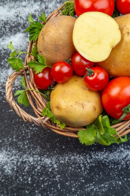 Photo vue verticale de crudités fraîches et vertes dans un panier en bois sur le côté gauche sur fond blanc noir