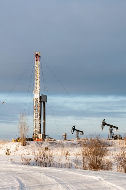 Vue verticale d'un derrick de forage et d'un cric de pompe en hiver rigoureux. Extraction d'huile. Notion de pétrole.