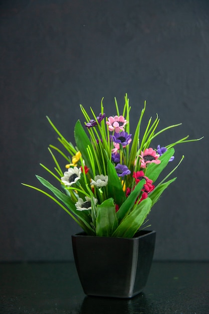 Vue verticale du pot de fleurs sur la lumière sur fond sombre avec espace libre