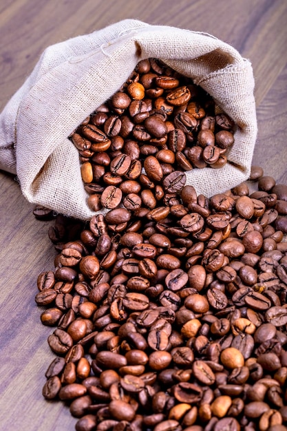 Vue verticale du sac en tissu naturel qui contient des grains de café pour la torréfaction nature morte concept de la journée internationale du café le 1er octobre