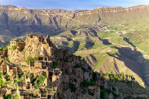 Vue sur le village inhabité de Gamsutl au sommet d'une montagne au Daghestan, le village habité de Chokh est visible au loin