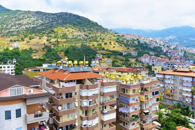 Vue de la ville de cottages modernes à plusieurs étages sur un flanc de montagne avec des arbres un jour d'été Turquie Alanya