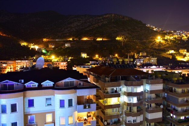 Photo vue de la ville de cottages modernes à plusieurs étages sur un flanc de montagne la nuit turquie alanya