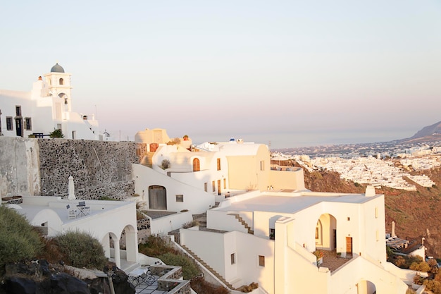 Vue de la ville de Fira depuis la ville d'Imerovigli au coucher du soleil sur l'île de Santorin en Grèce