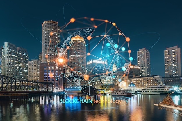 Vue sur la ville panorama du port de Boston et du Seaport Blvd la nuit Massachusetts Économie décentralisée Bâtiments extérieurs du centre-ville financier Blockchain et concept de cryptographie hologramme