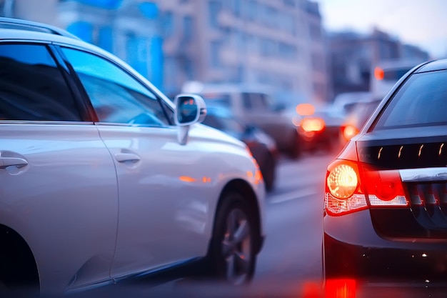 vue de la voiture dans les embouteillages / vue arrière du paysage depuis la fenêtre de la voiture, route avec voitures, lumières et jambes des voitures vue nocturne