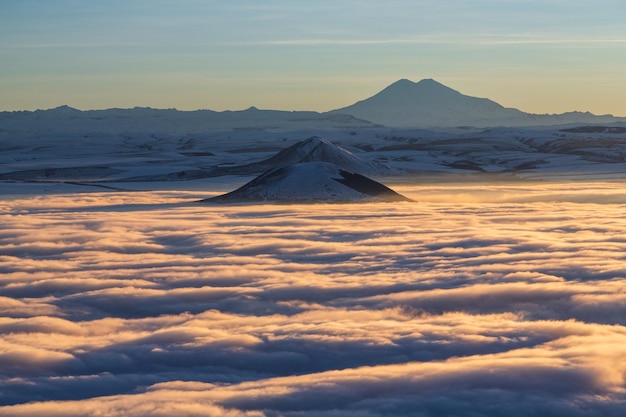 Photo vue sur le volcan elbrus sur les nuages au coucher du soleil depuis le mont mashuk à piatigorsk. caucase, russie