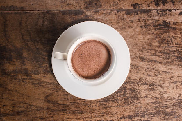 Vue zénithale d'une tasse de chocolat chaud sur une table en bois.