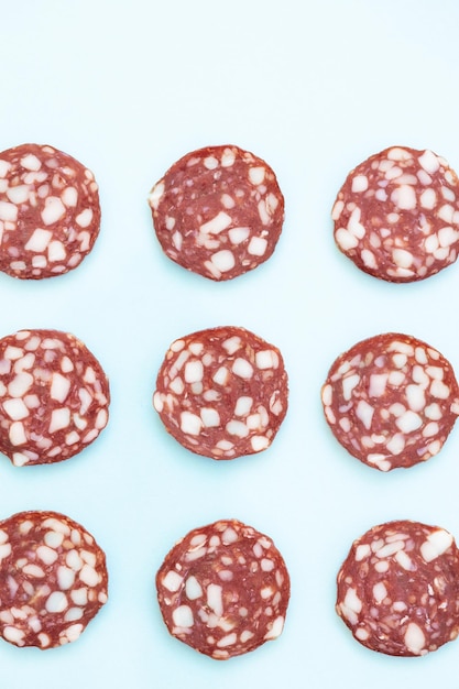 Vues de dessus et de côté des tranches de saucisse de salami fumées isolées sur fond bleu