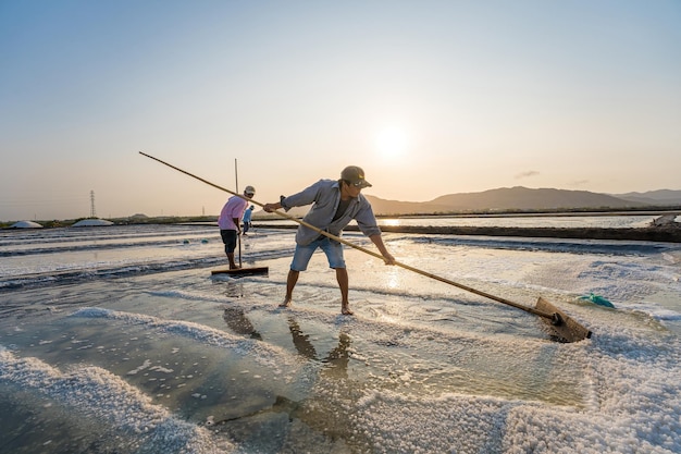 Vung Tau VIETNAM 18 MARS 2023 Le processus de sel de mer fabriqué à partir d'un tas de sel dans la saline par un travailleur de la zone rurale des champs de sel de Long Dien est l'une des destinations les plus uniques au Viet Nam
