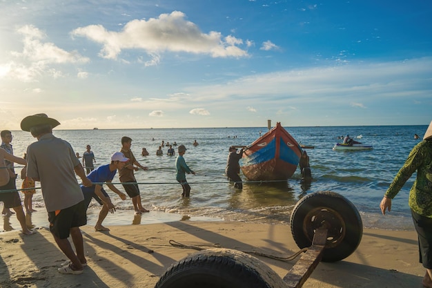 Vung Tau VIETNAM 20 AOÛT 2022 Pêcheur jetant son filet au lever ou au coucher du soleil Les pêcheurs traditionnels préparent le filet de pêche Les pêcheurs sur la plage à la pêche