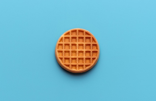 Waffle rond directement au-dessus vue isolée sur un fond bleu