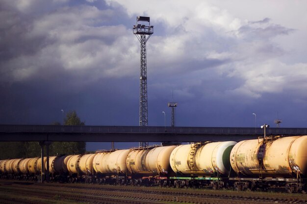 wagons de chemin de fer avec des produits pétroliers sur la gare avec un ciel sombre