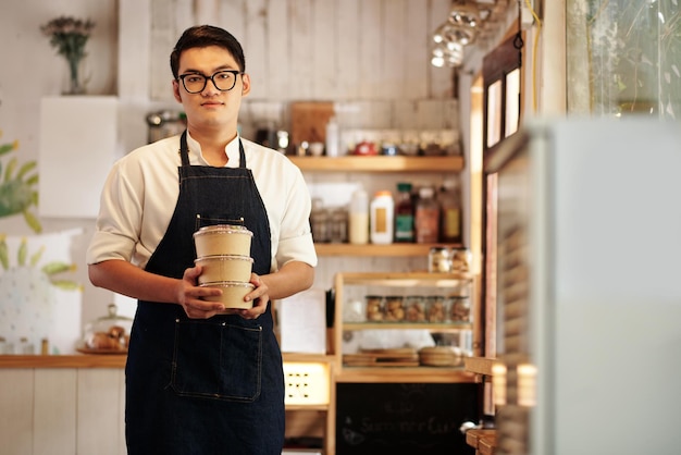 Waiter Holding Containers avec soupe fraîche